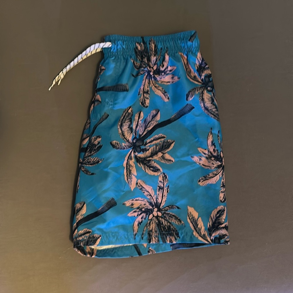 Blue with pink palm tree swim trunks. Size YL (10-12)
